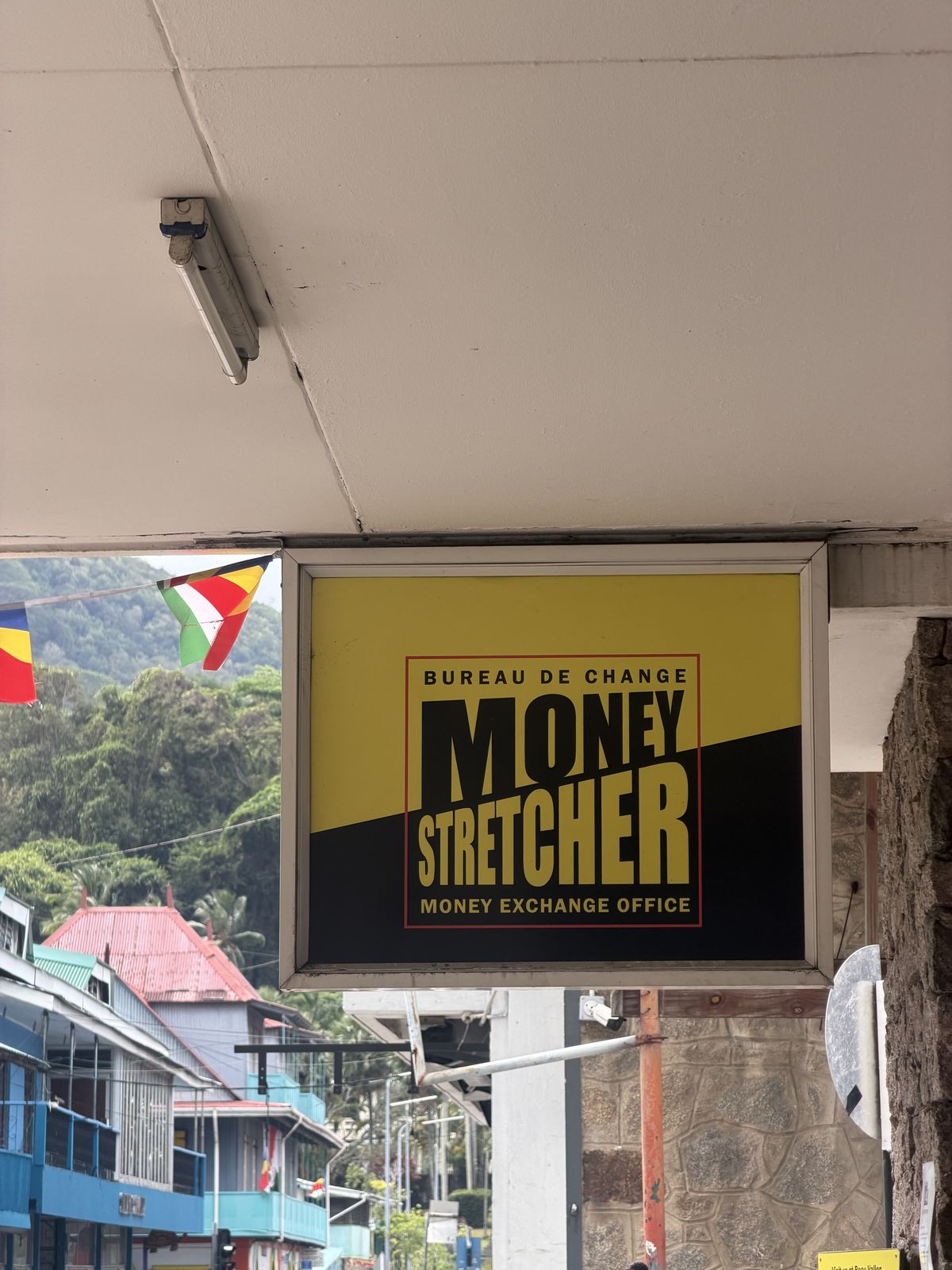 A bureau de change sign reading Money Stretcher, with the Seychelles flag behind