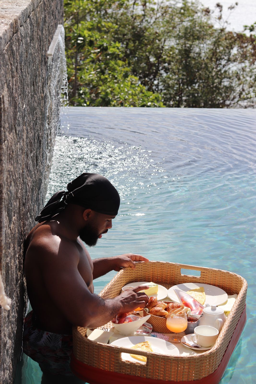 OJ in an infinity pool with a floating breakfast tray