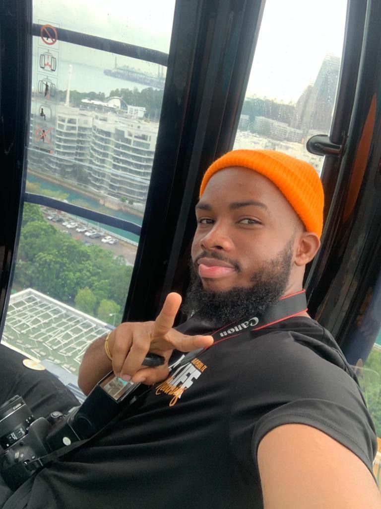 OJ in an orange beanie in a cable car above the city