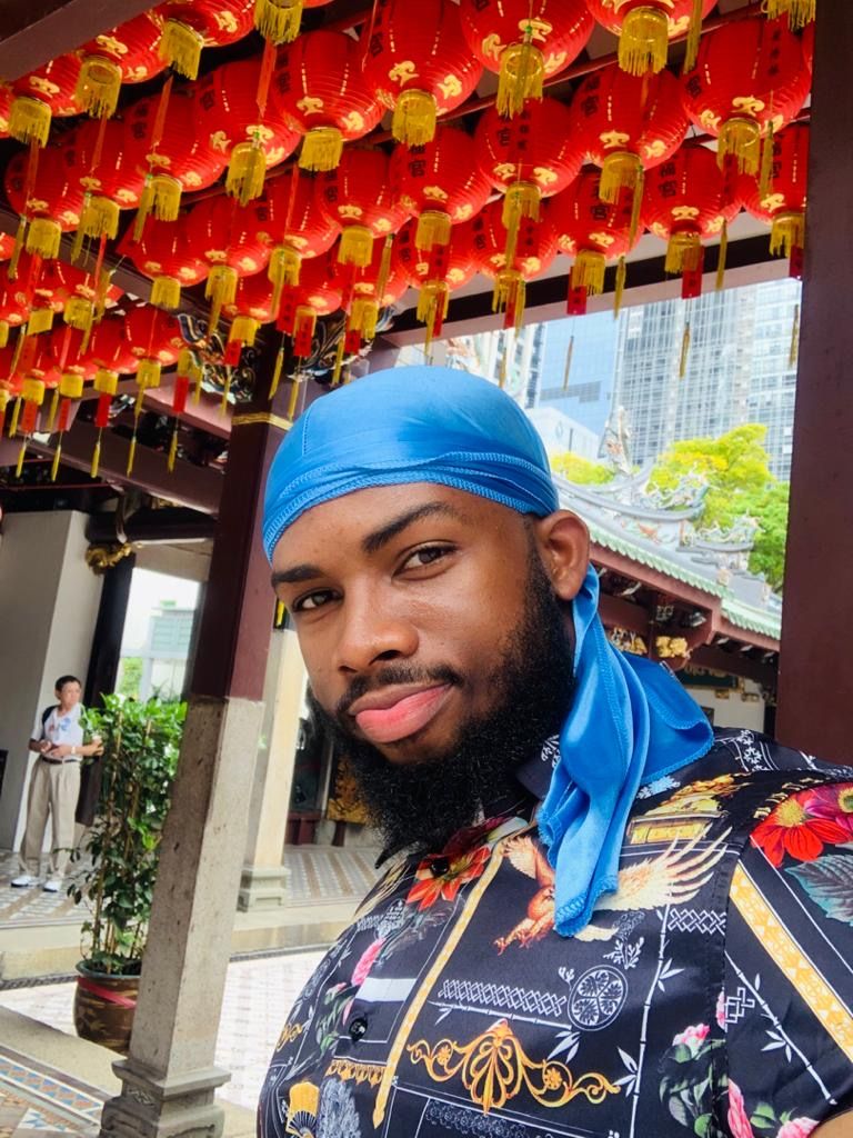 OJ under rows of red lanterns at a Chinese temple